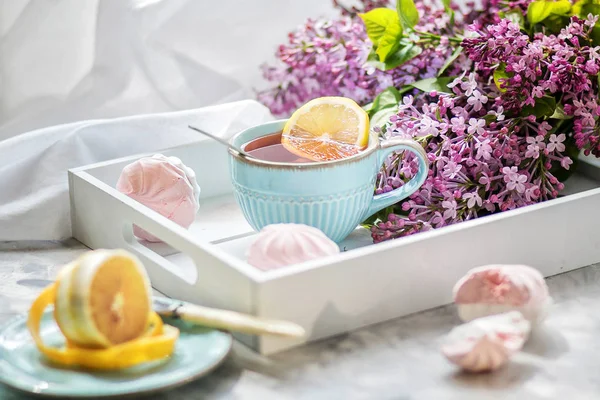 Çay marshmallow, limon ve bir buket leylak ile bir hediye kutusunda servis edilir. Yakından kapatın. Ön görünüm