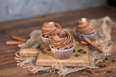 Lezzetli çikolata cupcakes ve tarçın çubukları ahşap bir tahta üzerinde. Ön görünüm. 
