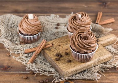 Lezzetli Çikolata Cupcakes ve ahşap tahta üzerinde tarçın çubukları. Üst görünüm. Seçici odak
