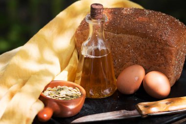 Ev yapımı taze ekmek, ayçiçek yağı ile şişe, eski bir metal fırın tepsisine bir bıçak ve yumurta. 