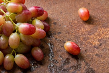 Paslı metal bir yüzeyüzerinde kırmızı üzüm kümesi. 