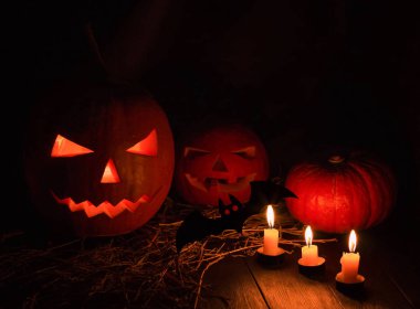 Siyah arka planda mumları olan bir cehennem balkabağı. Büyük ürkütücü cadılar bayramı sembolü