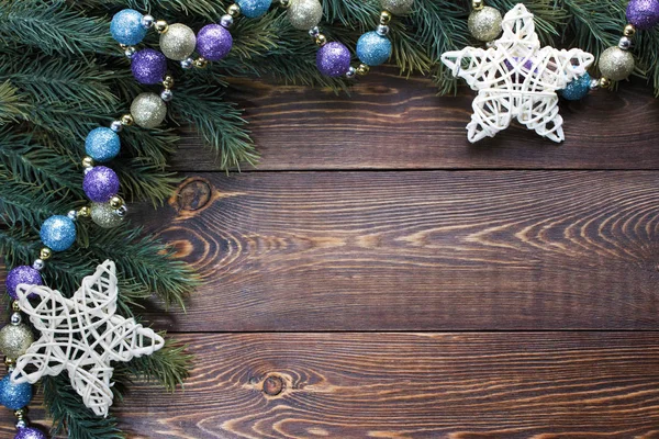Quadro de ramos de abeto, violeta, ouro e turquesa bolas de árvore de Natal e estrelas brancas sobre fundo marrom de madeira . — Fotografia de Stock