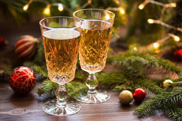 Deux verres de champagne sur la table en bois avec boules de Noël et branches de sapin . — Photo