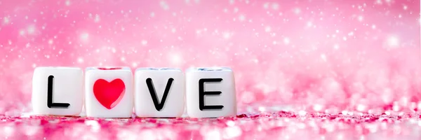 White Beads With Word Love And Red Heart Shape On Shiny Pink Glittering Background - Valentine's Day Concept