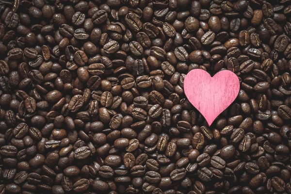 Pink heart on coffee beans