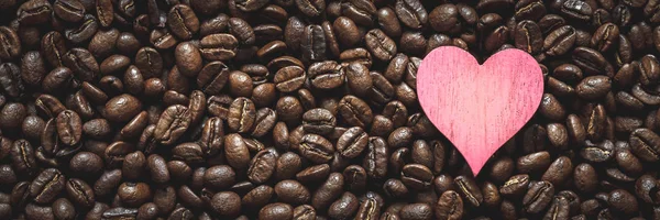 Pink heart on coffee beans