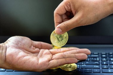 Bir işadamının eli, madeni para ödeyen bir adam, bir bitcoin şifrelemesi. Sanal dünyada bir bilgisayar ağı aracılığıyla finans alışverişinde bulunmak için, engelleme teknolojisini kullanarak dijital piyasalara yatırım yapın.