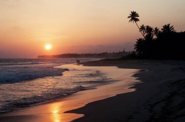 Koggala, Sri Lanka'da sahil şeridinin görünümü, gün batımında Hint okyanusundaki kayalar