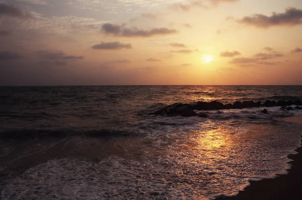 View of coast line in Koggala, Sri Lanka, boulders in the Indian ocean at the sunset