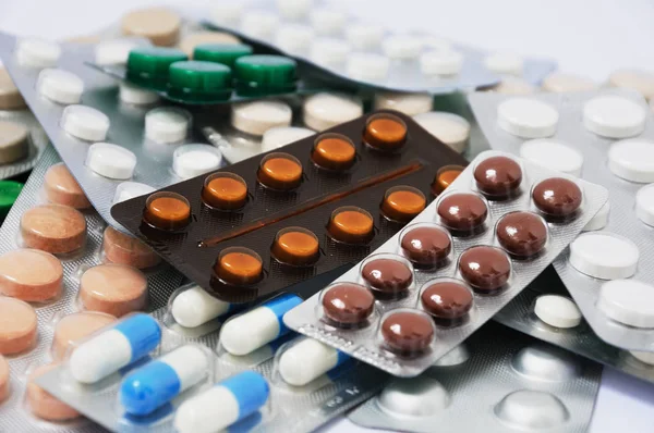 Comprimidos de medicamentos coloridos está no fundo branco . — Fotografia de Stock