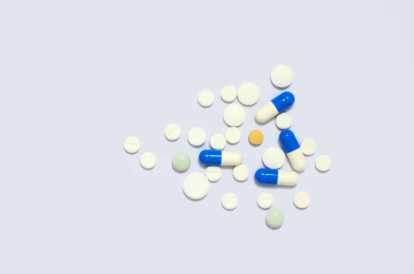 Comprimidos de medicamentos coloridos está no fundo branco . — Fotografia de Stock