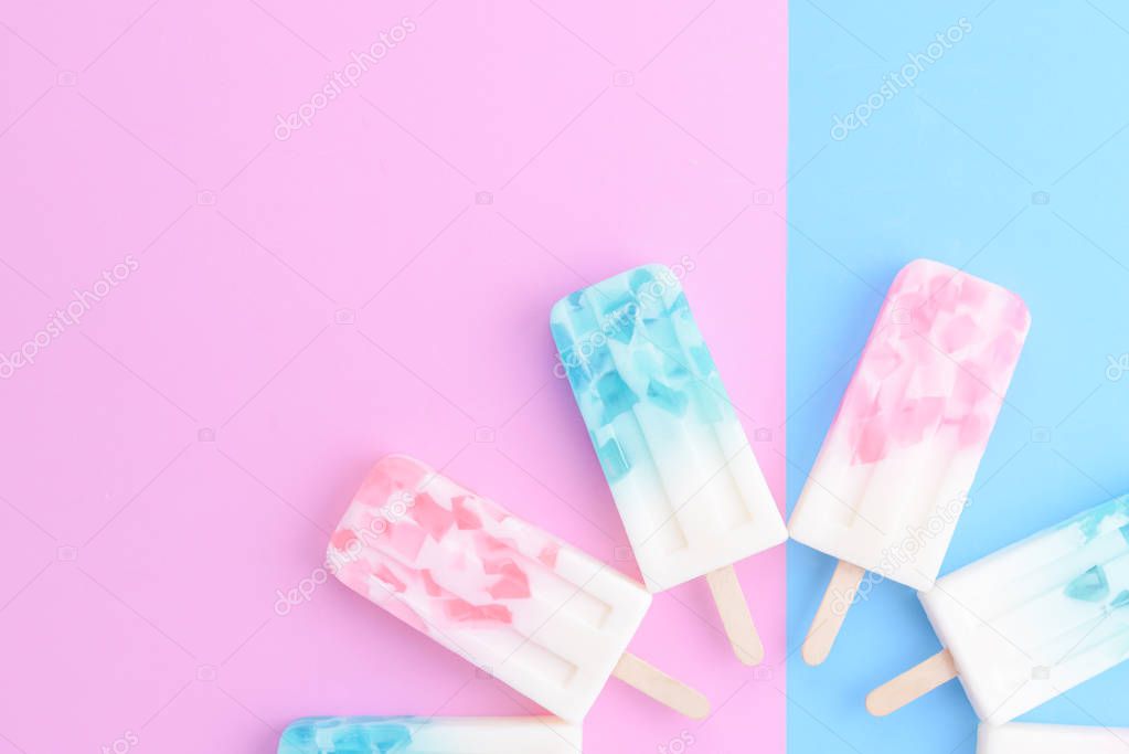 Homemade Ice cream sticks , popsicle , ice pop or freezer pop on blue and pink pastel colors background