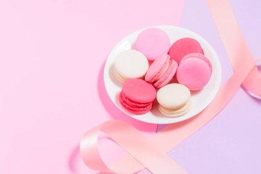 Ev yapımı renkli macaroons veya pembe ile beyaz tabakta macaron 