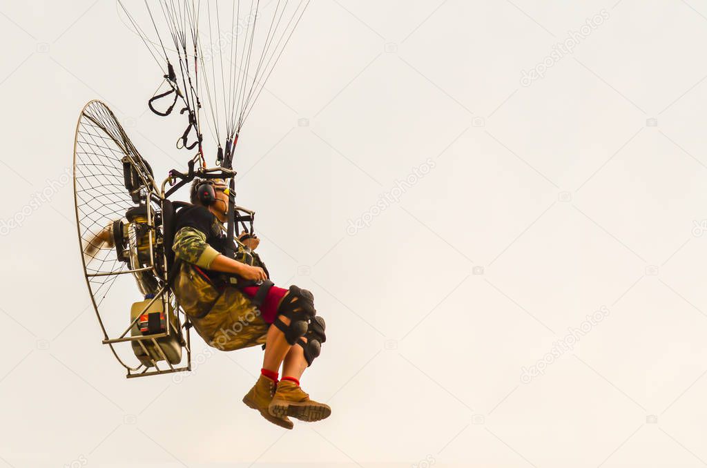 Paramotor flying on the clear sky background.
