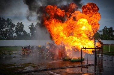 İnsanlar su ile yangın söndürme alıştırması yapıyorlar..