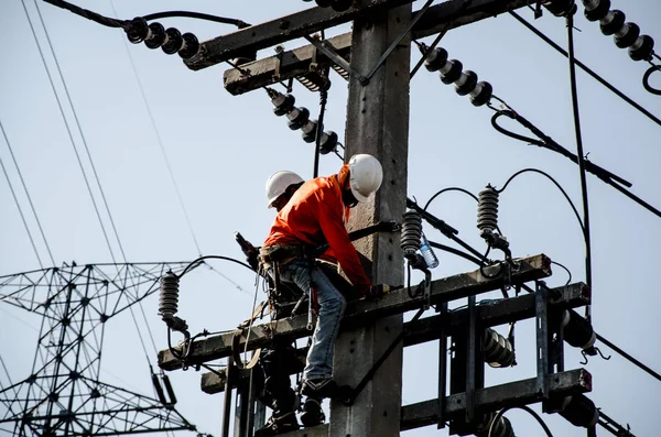 Teknisyenler elektrik direkleri üzerinde yüksek voltaj iletim sistemleri tamir.