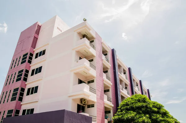 Purple dormitory building with blue sky background.
