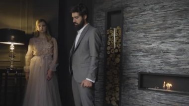 ağır çekim melankoli sarışın uzun saçlı Bayan masa lambası ve üzgün adam yakın eski moda dantelli elbise standları