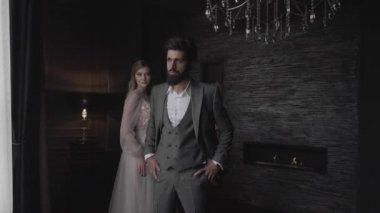 ağır çekim şiddetli sakallı adam şık takım elbise ve loş odasında şömine karşı pembe stand güzel ihale Bayan