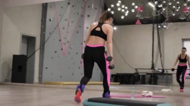 genç atletik kadın siyah dumbbells ahşap yere koyar ve koruyucu bandaj alır