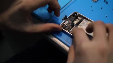 Görünümü Kapat profesyonel kişi iphone corpus parmak mavi masa örtü üzerinde düzeltme anakart eller
