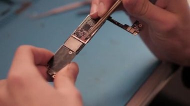 portre profesyonel asker iphone ses işlemci anakart üzerinde metal kıskaç ile gösterir