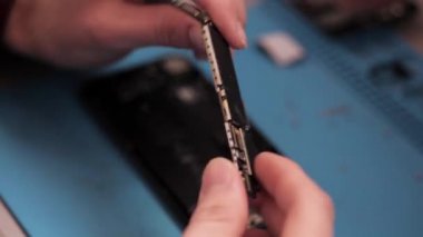 Görünümü Kapat kişi iphone anakart tutar ve kerpeten atölye ile ses işlemcisi gösterir