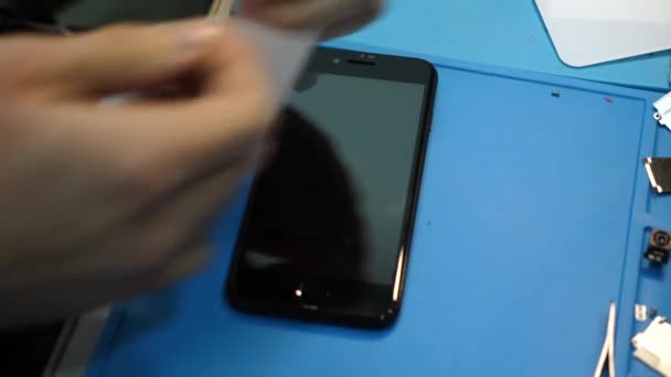 近距离观察专业修理工将防护玻璃贴在黑色 Iphone 并用超细纤维擦拭 — 图库视频影像