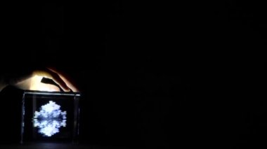 duvara yakın görünümünde ışık ile karanlık odada beyaz görüntü ile küçük ekran üzerinde elektrikli ışık ışını ile aydınlatılmış kız el