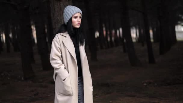 Fille en tricot chapeau et manteau marche à travers le bois au ralenti — Video