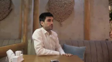 ayna yakınındaki küçük masada sipariş yapmak isteyen servis personeli aramak için umutsuz kafe konuk ıslık