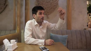 cep telefonu ile acele adam pizzacı ahşap masada kanepede oturan garson aramak için parmakları koparır