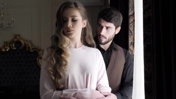 Man with three-day beard looks at young blond woman in white — Stock Video