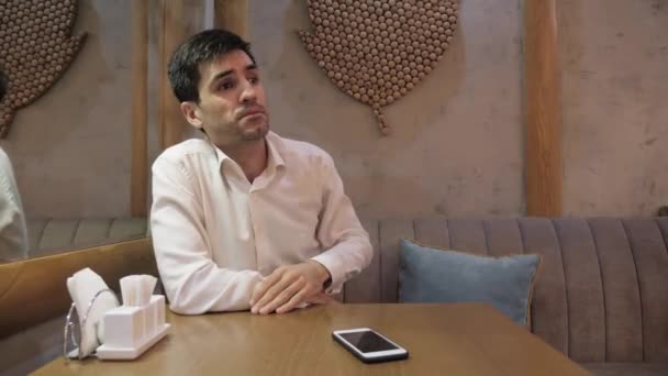 Mladý Podnikatel Chytrým Telefonem Stole Dělá Obličej Při Pohledu Číšníka — Stock video