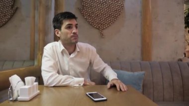 yorgun bekleyen kızgın ve aç kafe konuk rahat kanepede oturan duygusal jestleri ile gelmek için garson gösterir