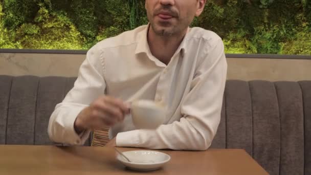 Homem Bonito Camisa Branca Com Xícara Café Chama Alguém Sofá — Vídeo de Stock