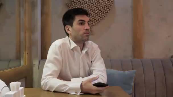 Pemuda Gugup Dengan Kemeja Putih Menjentikkan Jari Untuk Memanggil Pelayan — Stok Video