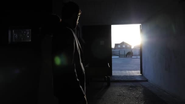 Młoda para sylwetki chodzić do drzwi oświetlony przez słońce slow motion — Wideo stockowe