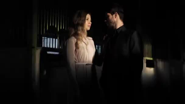 Facet i Ładna dama stoją w ciszy pod elektrycznym światłem — Wideo stockowe