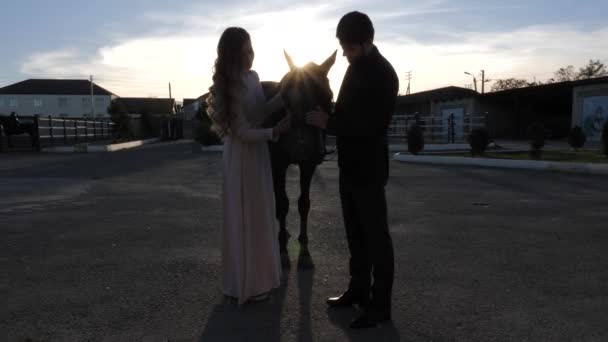 Silueta de niña en vestido largo y hombre en traje de caballo de compañía — Vídeos de Stock