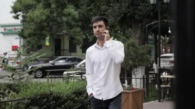 akıllı telefon gömlek ve kot görüşmeler rahat adam ve temiz teras ile modern restoran geçmiş yürüyor