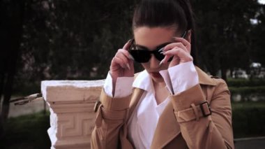 elinde uzun at kuyruğu ve güneş gözlüğü ile esmer gökyüzü yavaş hareket düşük açı çekim düşünceli görünüyor