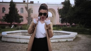 elinde uzun at kuyruğu ve güneş gözlüğü ile esmer gökyüzü yavaş hareket düşük açı çekim düşünceli görünüyor