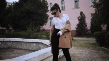 elinde uzun at kuyruğu ve güneş gözlüğü ile esmer gökyüzü yavaş hareket düşük açı çekim düşünceli görünüyor