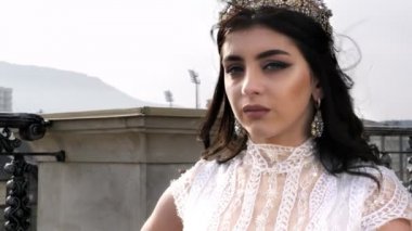 altın taç küpe ile bayan şehir ve gökyüzüne karşı duruyor