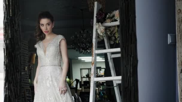 Молодая невеста с идеальной прической позирует в свадебном платье — стоковое видео