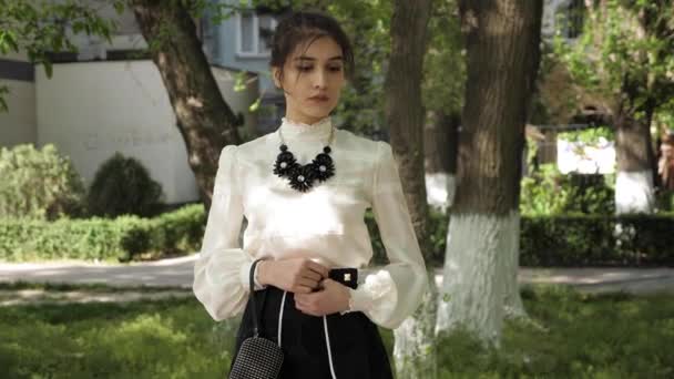 女孩在白色雪纺上衣和黑色裙子与项链 — 图库视频影像