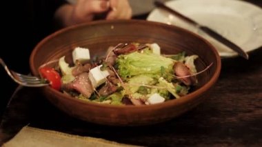 restoran ziyaretçi bıçak yakın görünümü ile porselen plaka karşı gümüş çatal üzerinde salata malzemeleri impales