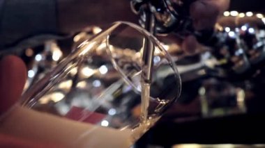 yetenekli barmen bulanık bar musluklar ve ahşap bar yakın görünümü yavaş hareket karşı cam kadehiçine köpüklü bira döker